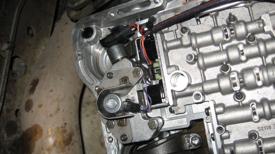 close-up of an automatic transmission valve body with wiring and solenoids