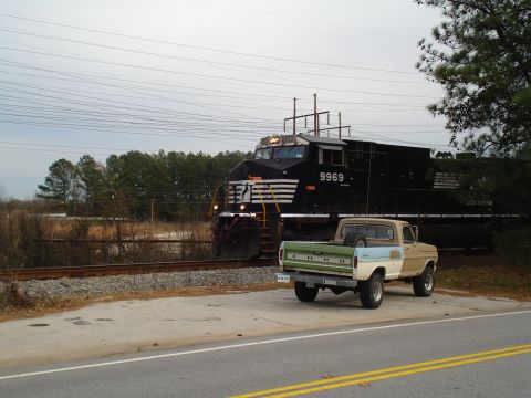 1967 Ford F-250 - A 1967 Ford F-250 pickup truck is parked near train tracks as a train passes by.