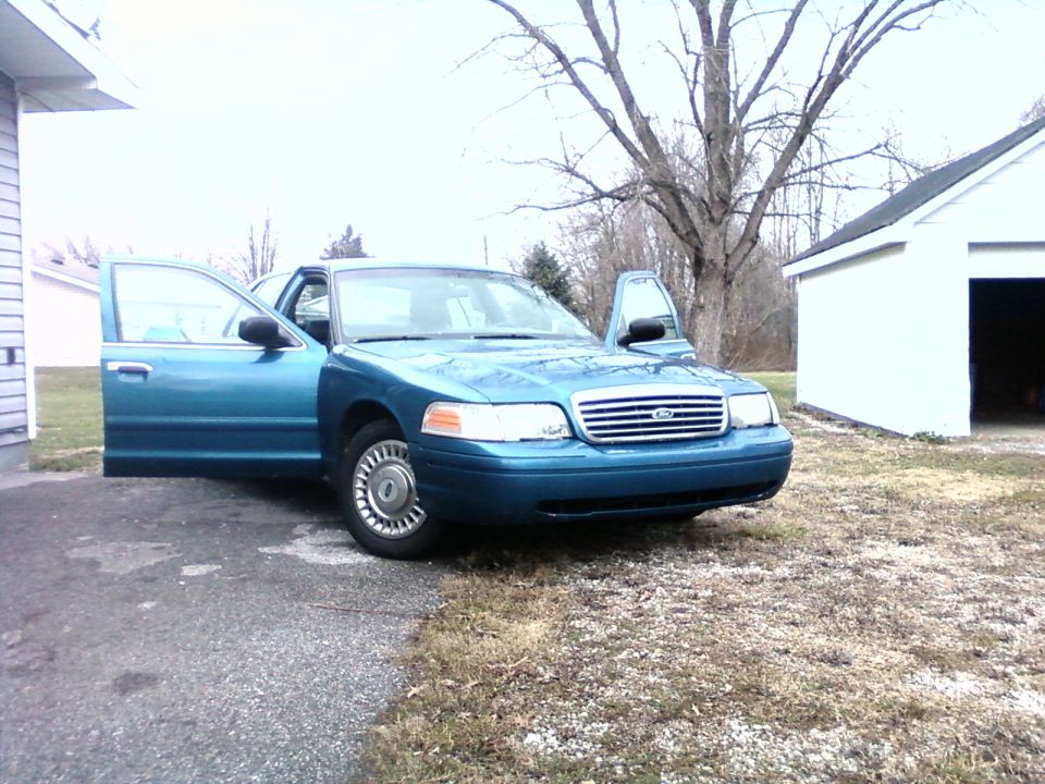 1998 Ford Crown Victoria parked outside with front doors open