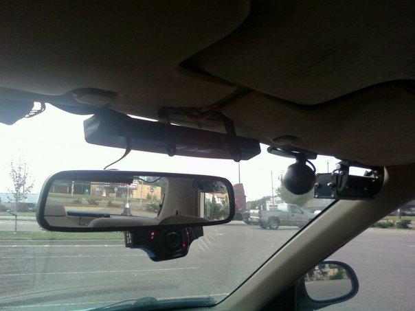 Interior view of a 2000 Mercury Grand Marquis showing a dashcam mounted below the rearview mirror and a red first aid kit above