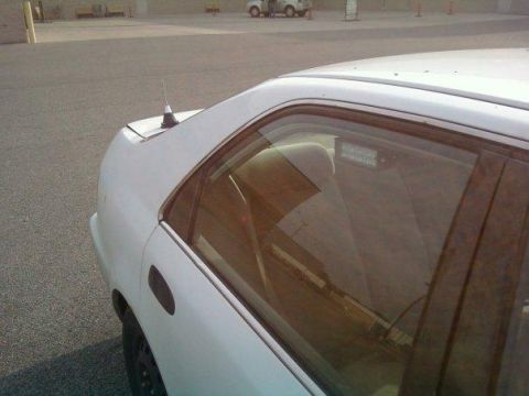 2000 Mercury Grand Marquis - Side view of a white sedan, showing the rear quarter panel and window.