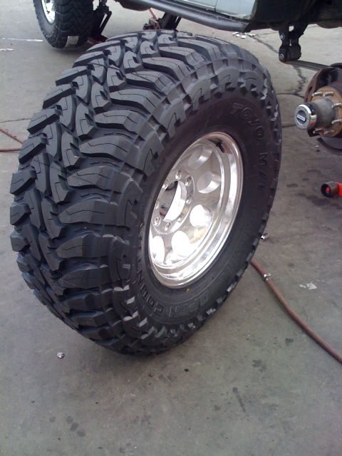 1996 Ford C-350 (Centurion Conversions) - A large Toyo tire and chrome wheel are shown, with another vehicle's suspension in the background.