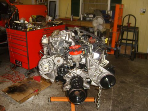 1994 Ford Bronco - Engine assembly on an orange engine stand in a garage setting.