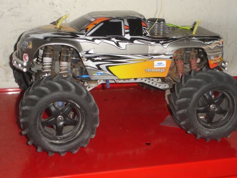 1989 Ford Bronco - This remote control monster truck features a striking silver and orange graphic design and oversized off-road tires.