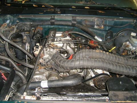1994 Ford Bronco - The engine compartment of a vehicle, showing various mechanical parts and wiring.