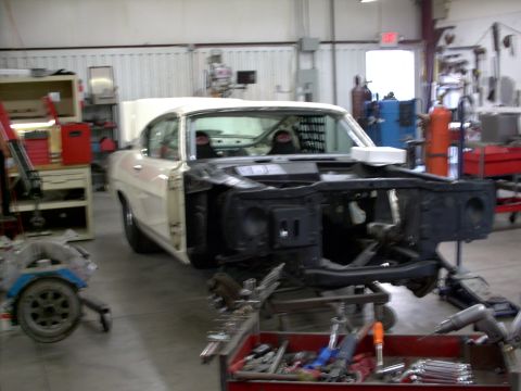 1963 Ford Fairlane - A white 1963 Ford Fairlane is undergoing repairs in a workshop, with its front end disassembled.