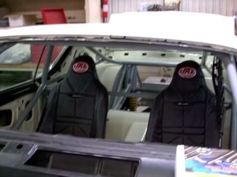 1963 Ford Fairlane - The interior of a car is visible, showing racing seats and a roll cage, suggesting a modified vehicle.