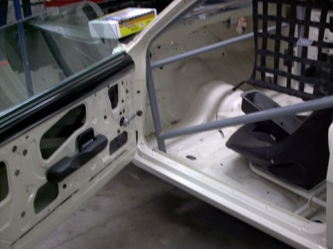 1963 Ford Fairlane - Interior view of a stripped-down car with a roll cage and racing seat installed.
