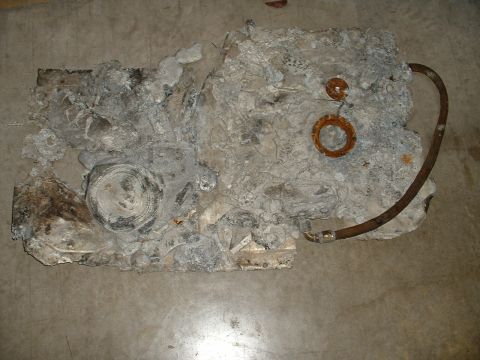 1963 Ford Fairlane - This heavily damaged engine block shows signs of extreme wear and tear, with a rusty hose still connected.