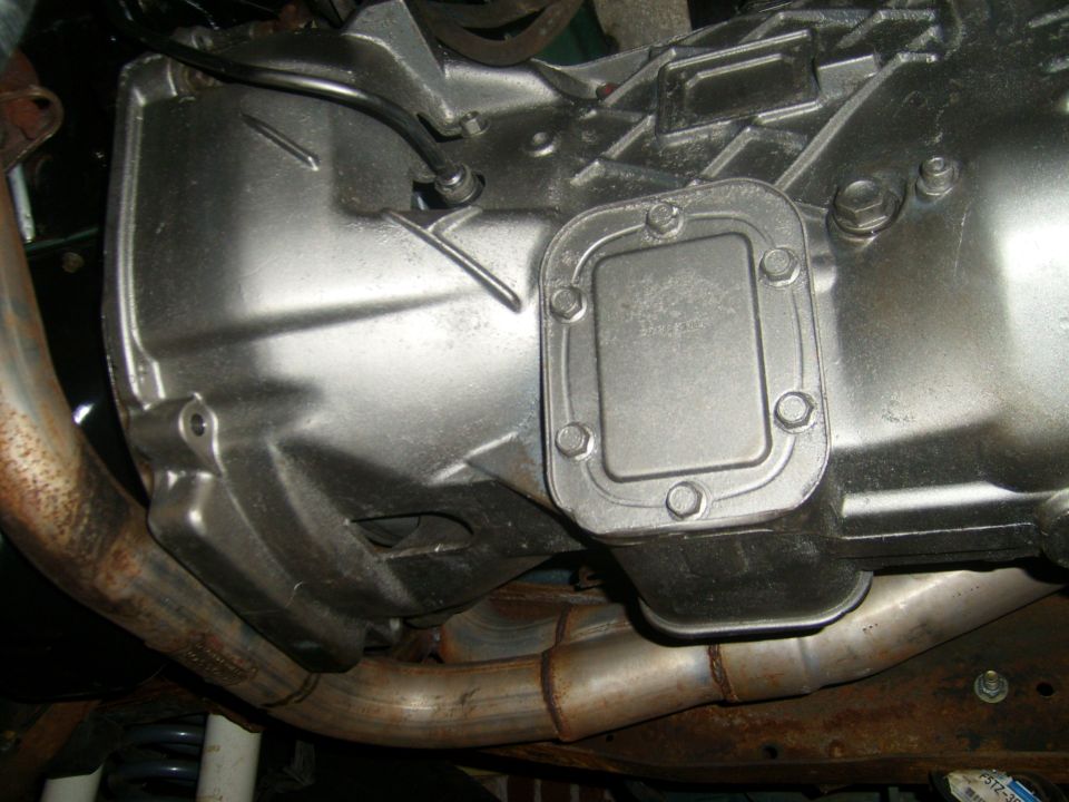 Close-up of a vehicle's transmission housing and exhaust pipes