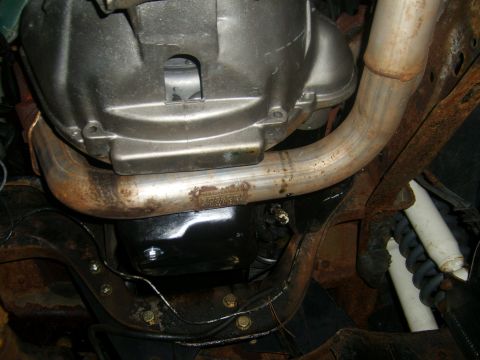 1994 Ford Bronco - Underside view of a vehicle's exhaust pipe and transmission components.