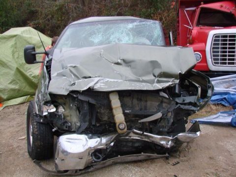 1995 Ford Bronco - This truck sustained significant front-end damage, with a red truck visible behind it.