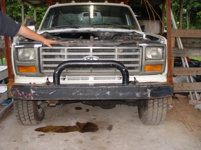White truck front view with open hood and bull bar. Circa 1980s