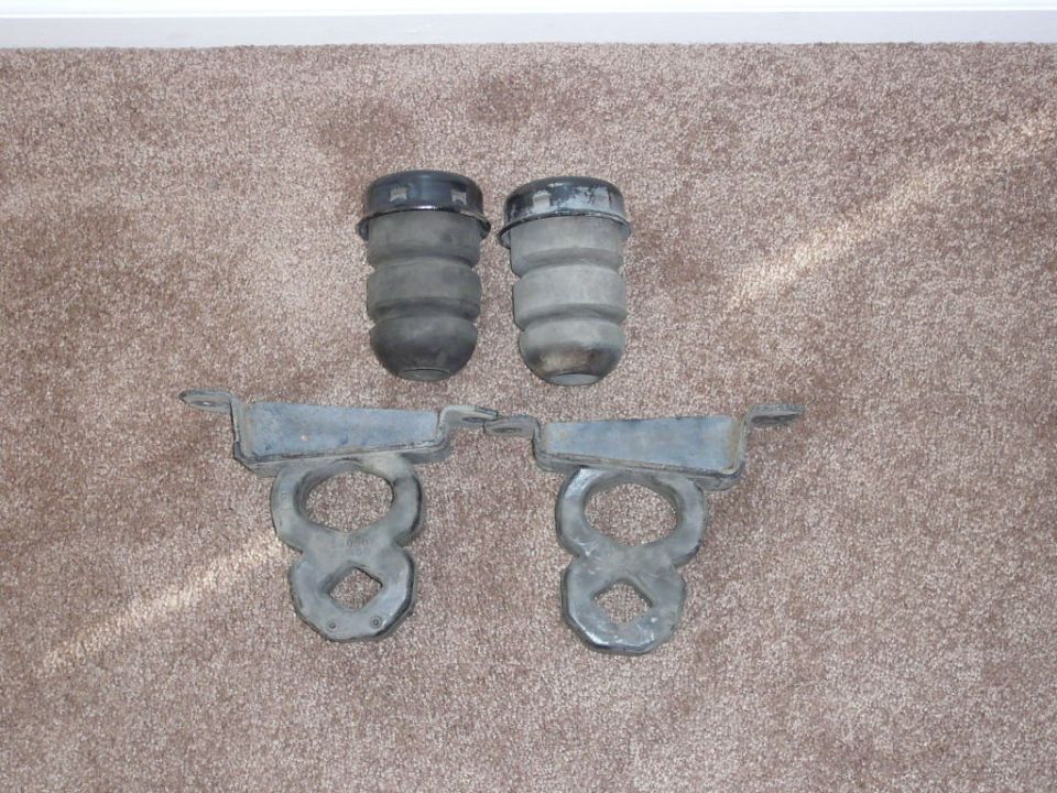 Pair of rear bumperettes and mounting brackets on carpet