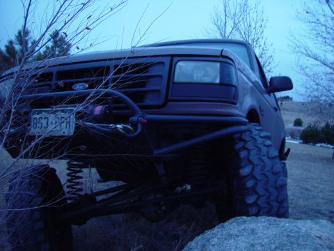 1993 Ford Bronco - This modified 1993 Ford Bronco features oversized tires and a custom front bumper, suggesting off-road capabilities.