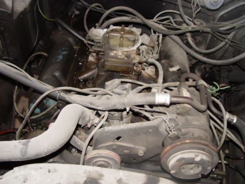 1996 Ford Bronco - Close-up view of an engine bay, focusing on the carburetor and associated components.