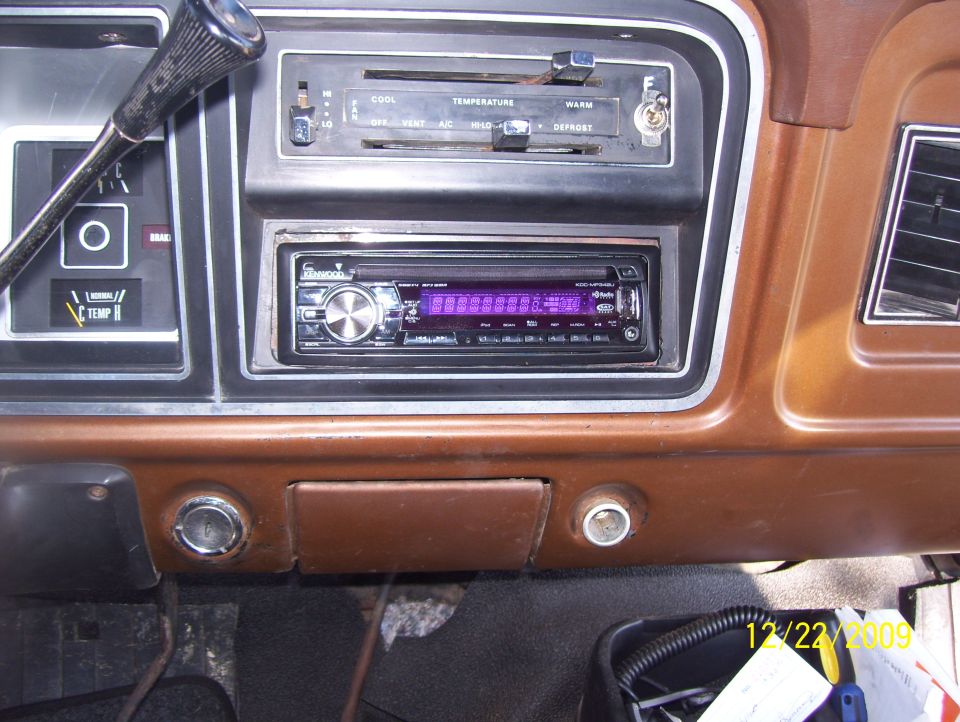 Brown dashboard interior with aftermarket stereo, climate controls, and gauges. Visible date stamp reads 12/22/2009