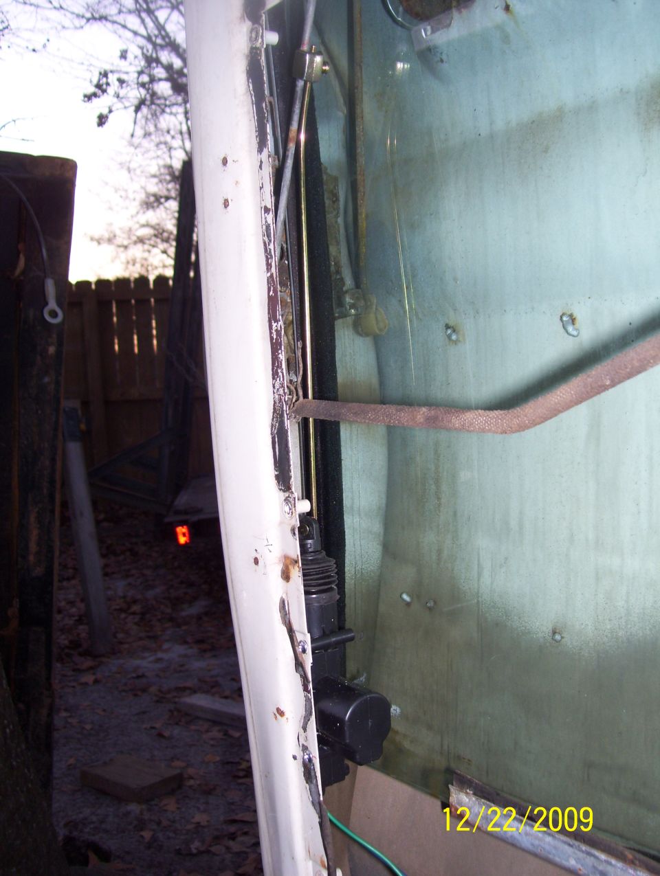 White door frame with black latch mechanism and metal rod