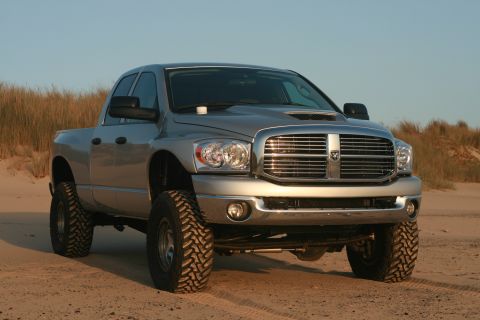 2006 Dodge 2500 - This silver 2006 Dodge 2500 pickup truck is shown on a sandy beach with its lifted suspension and aggressive off-road tires.