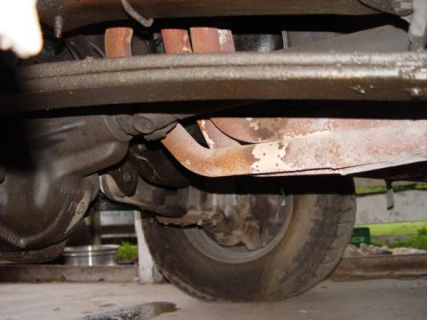 1996 Ford Bronco - Underside view shows rusted exhaust manifold pipes and suspension components.