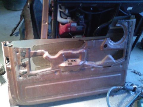 1990 Ford Bronco - Interior view of a brown door panel, showing its internal structure and mounting points.