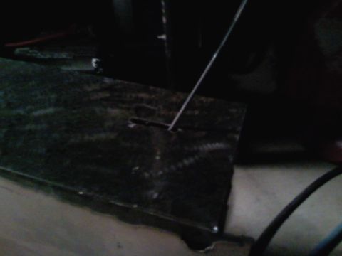 1990 Ford Bronco - Close-up of an unidentified dark interior part with a thin wire extending from a slot.