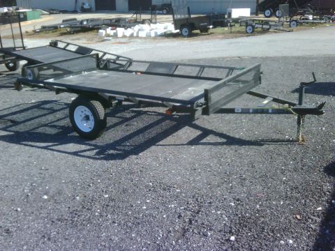 2004 Ford F-150 - A utility trailer with a mesh deck and fold-up ramps is parked on a gravel lot.