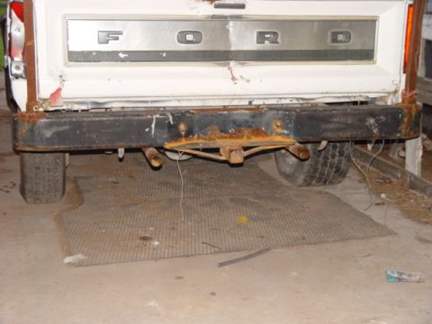 1996 Ford Bronco - Rear view of a Ford truck, showing the tailgate and heavily rusted bumper with a trailer hitch.