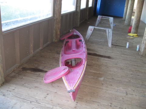 1991 Ford Bronco - A pink kayak rests on a weathered wooden deck, with a covered area and support posts visible in the background.