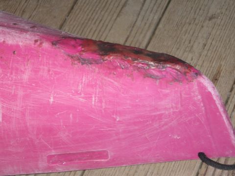 1991 Ford Bronco - This pink plastic part shows significant damage, including scratches and a burnt area along the edge.