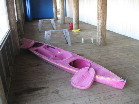 1991 Ford Bronco - A pink kayak and paddle rest on a wooden deck, with sawhorses and canisters visible.