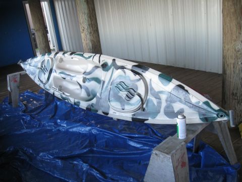 1991 Ford Bronco - A kayak with a camouflage paint scheme is shown resting on sawhorses, with a can of spray paint nearby.
