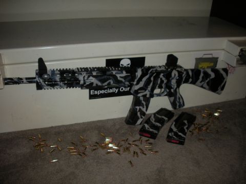 1996 Ford Bronco - An assault rifle with a distinctive camouflage pattern is displayed with its magazines and ammunition.