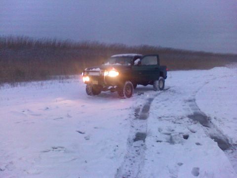 1998 Dodge 1500 - A 1998 Dodge 1500 pickup truck navigates a snowy landscape with its headlights illuminated.
