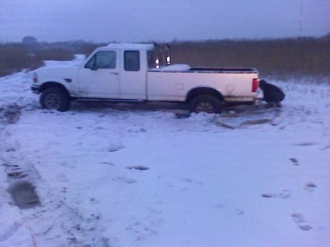 1998 Dodge 1500 - White pickup truck is stuck in a snowy field, with a person near the rear bumper.