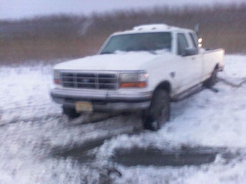 1998 Dodge 1500 - A white pickup truck is stuck in the snow, with its front end facing the camera.