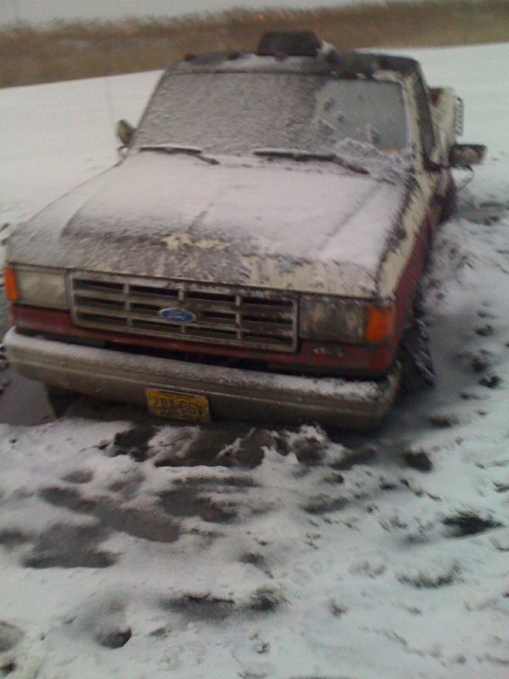 Ford pickup truck stuck in snow, covered in ice. Yellow license plate visible