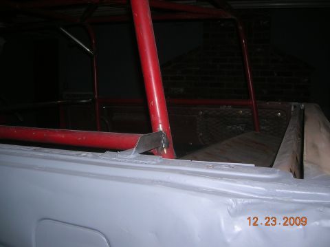 1985 Ford Bronco - The interior of a vehicle shows a red roll cage and unfinished bodywork, with a date stamp of 12.23.2009.