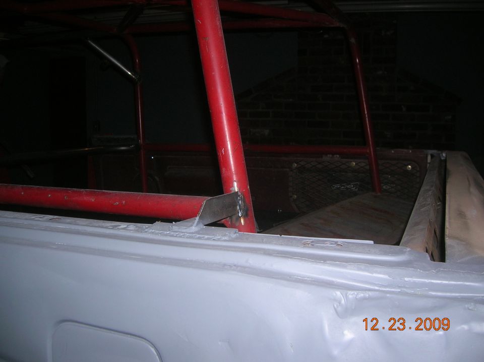 Vehicle interior with red roll cage and unfinished body panels. Date stamp reads 12.23.2009