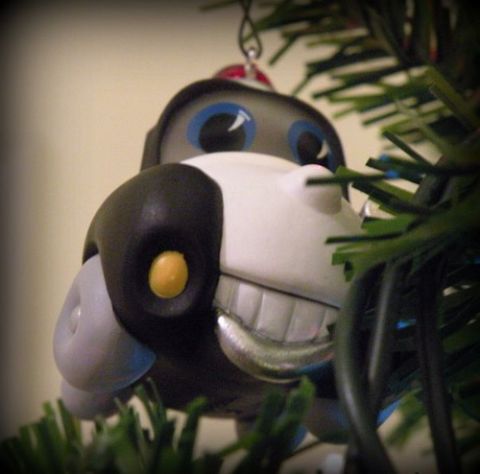 1991 Ford Crown Victoria - A festive dog ornament hangs among the branches of a Christmas tree, its wide grin adding a touch of holiday cheer.