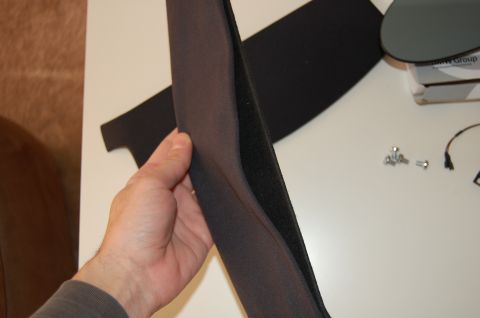 2002 BMW M3 - A person holds a car interior trim piece. Hardware and a BMW Group box are visible on the table.