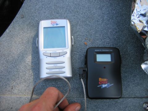 1992 Ford Bronco - A hand holds a probe connected to a digital meat thermometer and its remote transmitter.