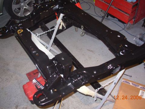 1991 Ford Taurus - A black painted vehicle frame assembly is shown on a stand, with a wheel visible in the background. The date 12.24.2009 is visible.