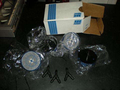 Suzuki Samurai - New Walbro fuel pumps still sealed in plastic bags with blue-and-white filter socks, laid out on a dark workbench next to their open Walbro…