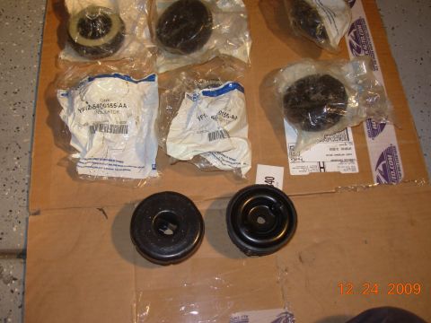 1991 Ford Taurus - New suspension parts are laid out on cardboard, showing part numbers and branding.