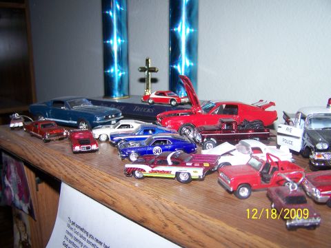 1972 Ford Ranchero - A variety of model cars are displayed on a shelf, some with hoods open.