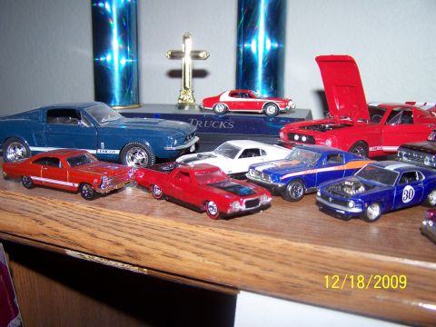 1972 Ford Ranchero - A collection of model cars, including a red 1972 Ford Ranchero, displayed on a shelf with trophies.