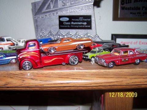 1972 Ford Ranchero - Toy car collection displayed on a wooden shelf with awards in the background.