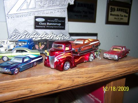 1972 Ford Ranchero - A collection of toy cars and trucks are displayed on a wooden shelf, with awards in the background.