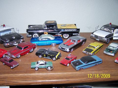 1972 Ford Ranchero - A collection of toy cars is displayed on a wooden shelf, various models and colors.